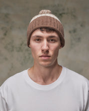 Front view of model wearing the khaki Fair Isle pattern hat from Uskees, clearly showing the ribbing of the adjustable cuff.