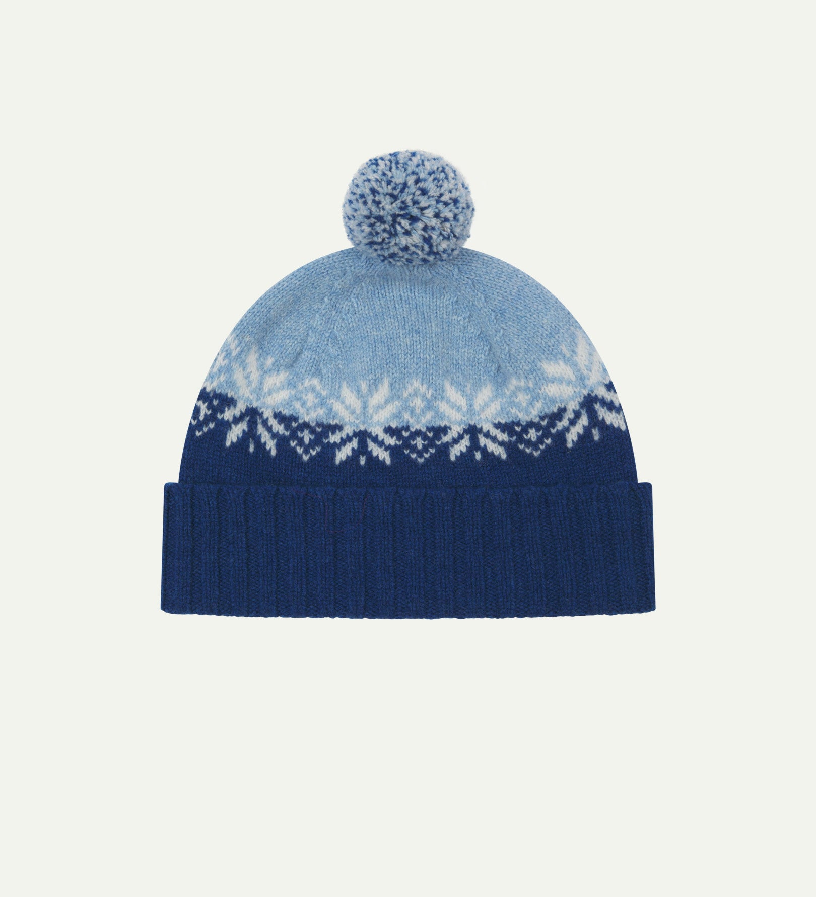 Front view of Uskees 4012 'ultra blue' lambswool snowflake hat, with a clear view of the ultra blue, powder blue and white colourway, snowflake motif and bobble.