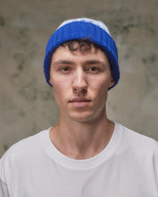 Front view of model wearing the ultra blue Fair Isle pattern hat from Uskees, clearly showing the ribbing of the adjustable cuff.