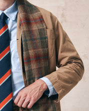 Close-up view of model wearing 4013 clay tartan scarf from Uskees, with detailed view of intersecting greens, blues and browns to create the 'Clay Tartan' pattern.