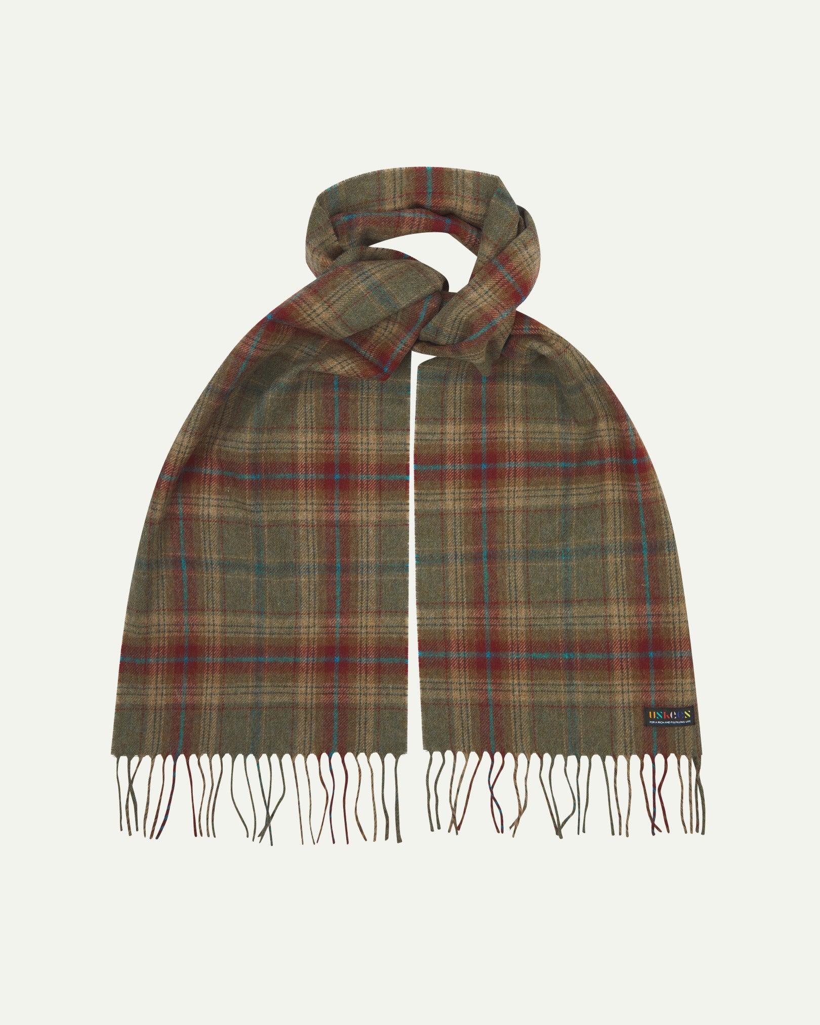 Uskees scarf presented on a flat white surface - tied and showing the green and red check pattern and tassels.