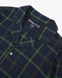 Close up shot of Uskees men's blue/green plaid pyjama  top  showing the brand label at neck.