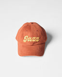Chestnut brown Uskees 6-panel cap with 'Jazz' embroidered motif in gold.