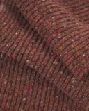 Close-up of the Donegal Merino wool scarf in speckled brick red, showing the ribbed texture and speckled coloured neps.