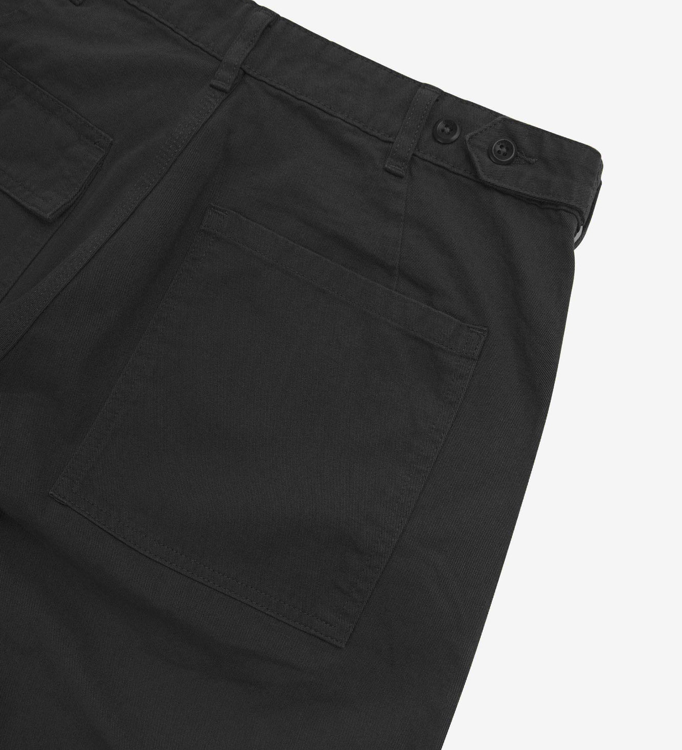 Close up back shot of Uskees 5005 twill workwear pants in black with focus on back pocket, adjustable waistband secured with Corozo button and belt loops.