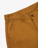 Close up view of a pair of Uskees drill trousers for men in a warm mustard yellow showing the waistband, belt loops and button fastening.