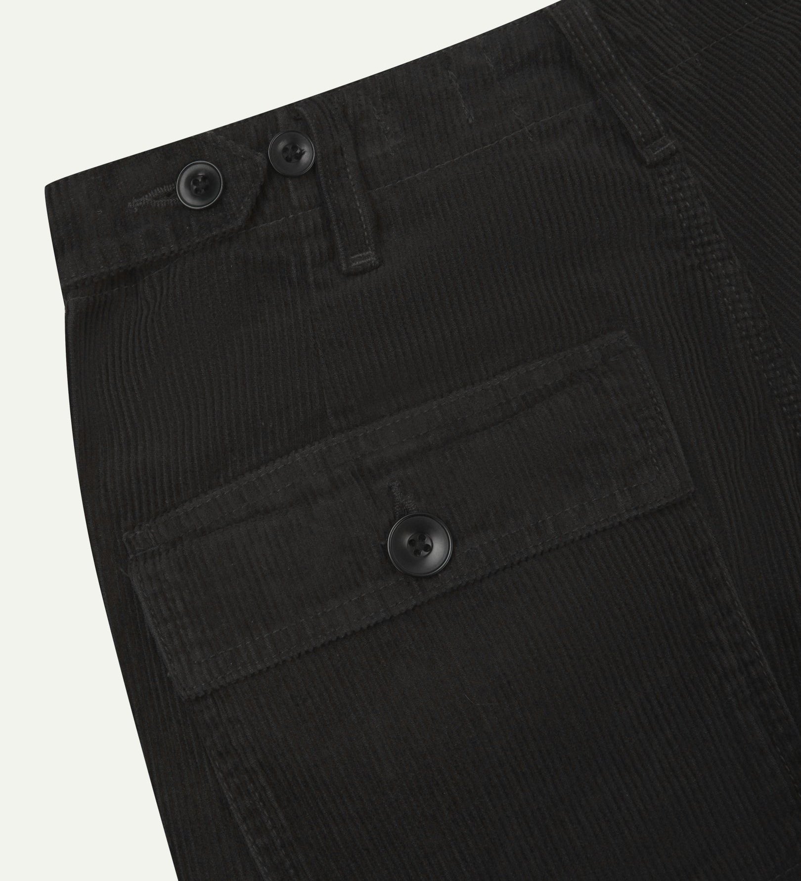 Close-up reverse view of Uskees charcoal-grey corduroy work pants with focus on left rear flap pocket, belt loops and adjustable button waist.