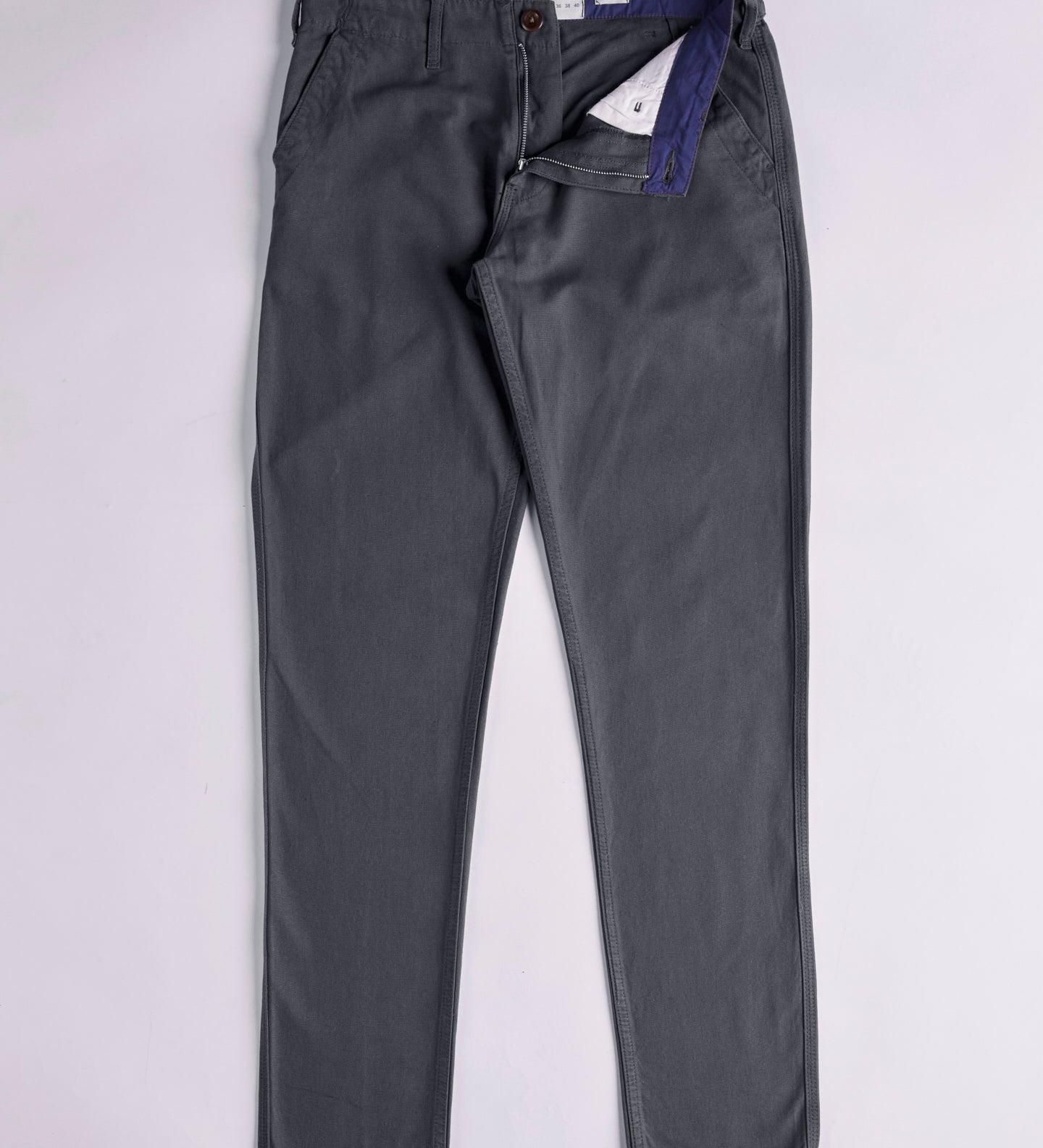 Front flat view of 5005 Uskees men's organic cotton charcoal-grey casual trousers. Zip down to reveal corozo button, contrasting lining and Uskees branding label. Discontinued colour.