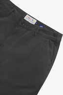 Close up of waist area of twill workwear pants in charcoal-grey. Clear view of front pocket, Corozo button fastening, Uskees branding label and organic cotton twill weave.
