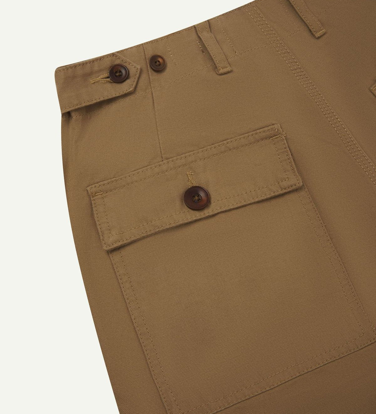 Close-up reverse view of Uskees khaki cotton work pants with focus on left rear pocket, belt loops, triple stitching and adjustable button waist.