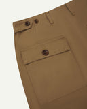 Close-up reverse view of Uskees khaki cotton work pants with focus on left rear pocket, belt loops, triple stitching and adjustable button waist.