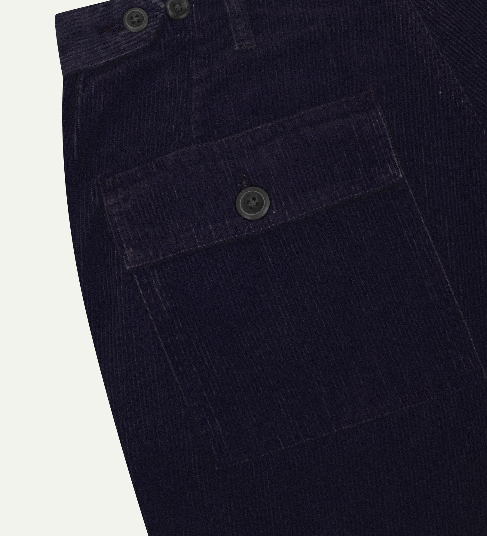 Close-up reverse view of Uskees midnight blue corduroy work pants with focus on left rear pocket, belt loops, triple stitching and adjustable button waist.
