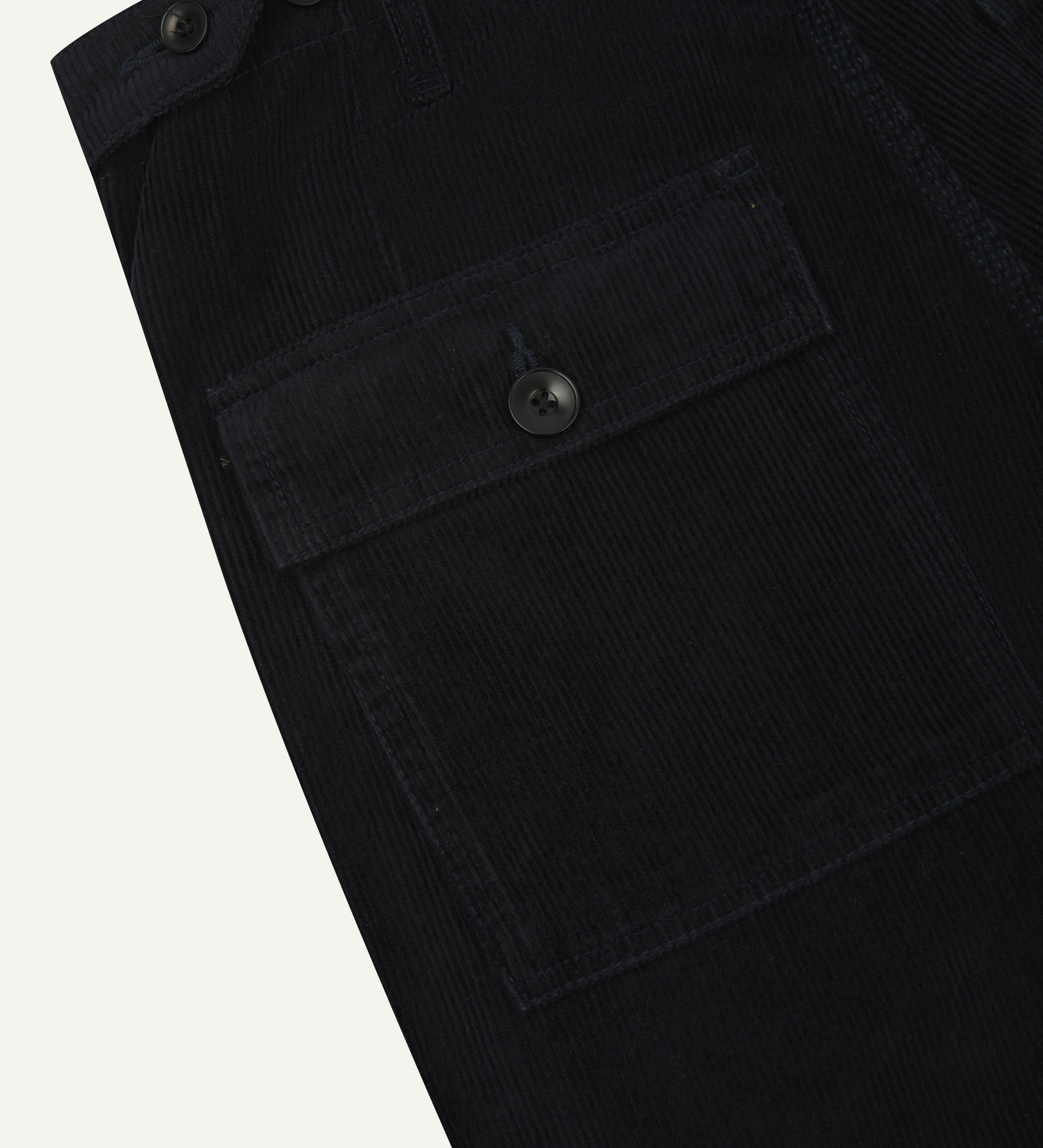 Close-up reverse view of Uskees midnight blue corduroy work pants with focus on left rear pocket, belt loops, triple stitching and adjustable button waist.