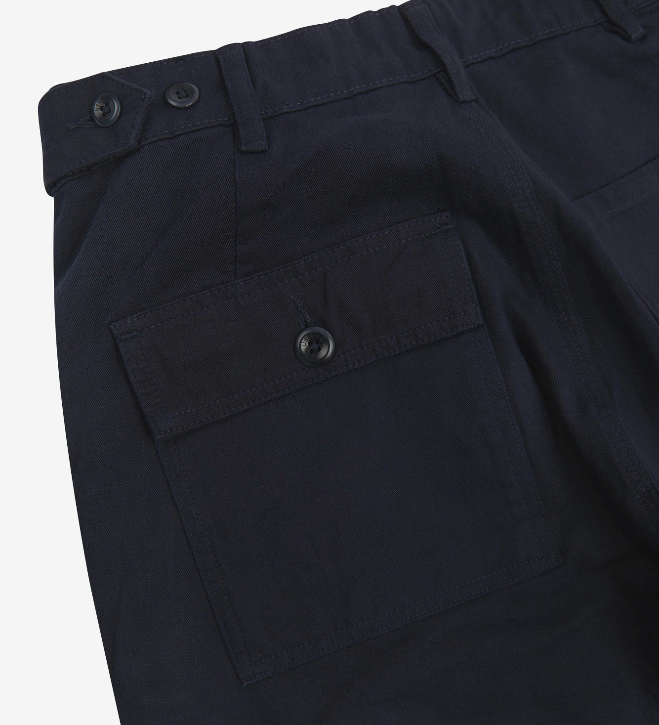 Close up back shot of Uskees 5005 twill workwear pants in deep blue with focus on back pocket, adjustable waistband secured with Corozo button and belt loops.