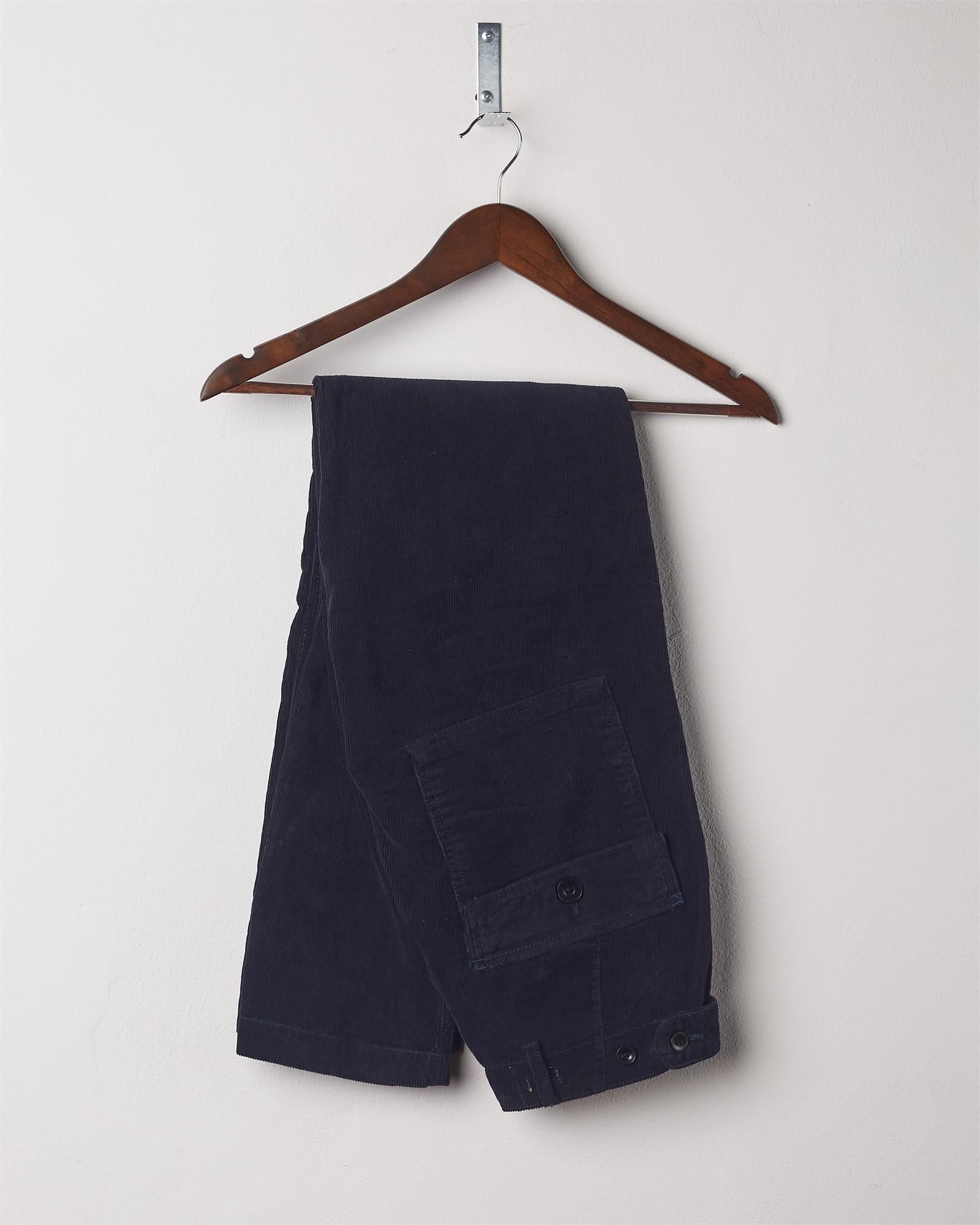 Folded hanging shot of #5005 Uskees men's organic cord 'midnight blue' casual trousers.