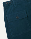 Close-up reverse view of Uskees petrol blue corduroy work pants with focus on left rear flap pocket, belt loops and adjustable button waist.