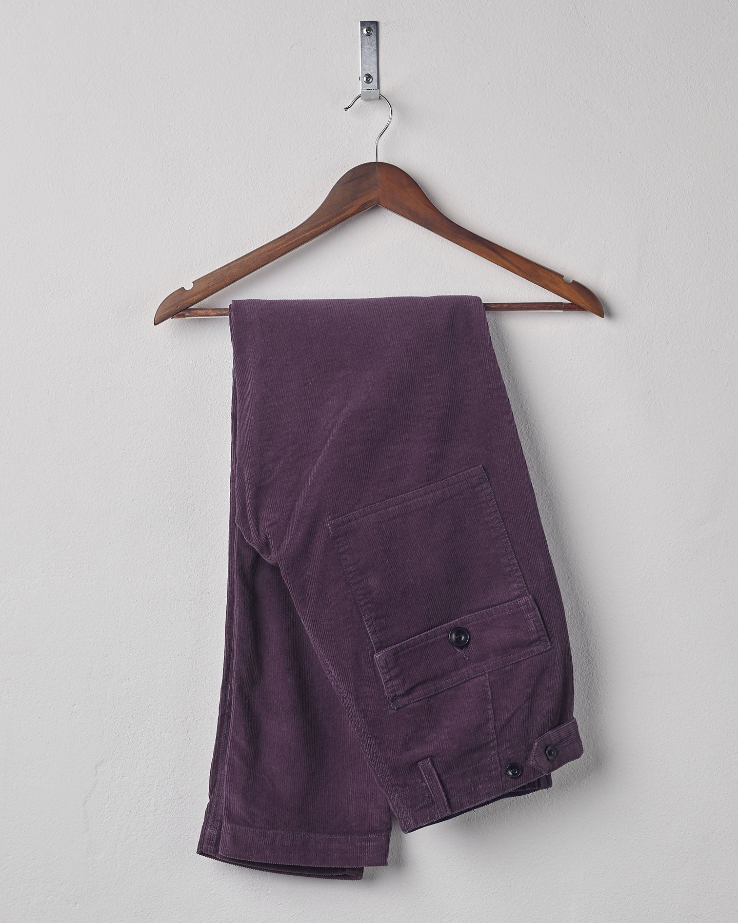 Folded hanging shot of #5005 Uskees men's organic cord 'purple-plum' casual trousers.