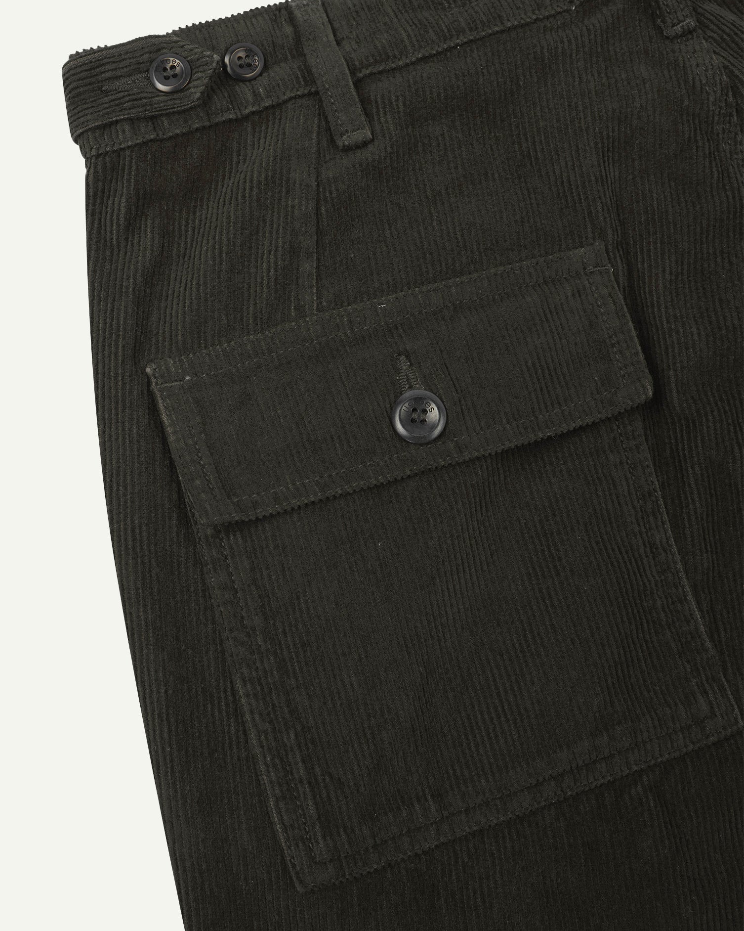 Close-up reverse view of Uskees green-brown (seaweed) corduroy work pants with focus on left rear flap pocket, belt loops and adjustable button waist.