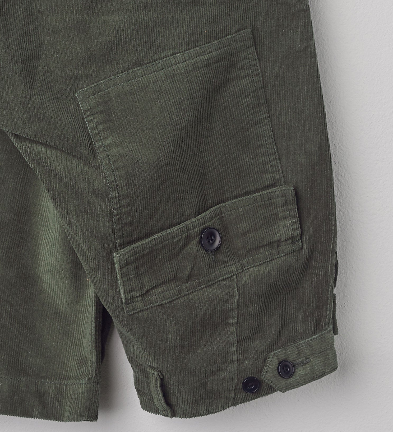 Close-up folded view of #5005 Uskees cord workwear pants in vine green showing triple stitching.