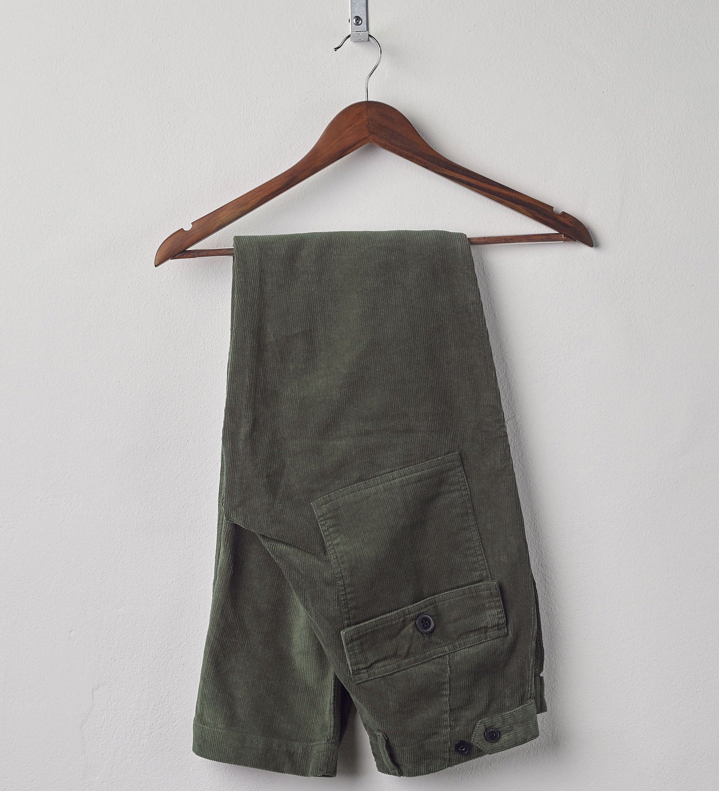 Folded hanging shot of #5005 Uskees men's organic cord 'vine green' casual trousers.