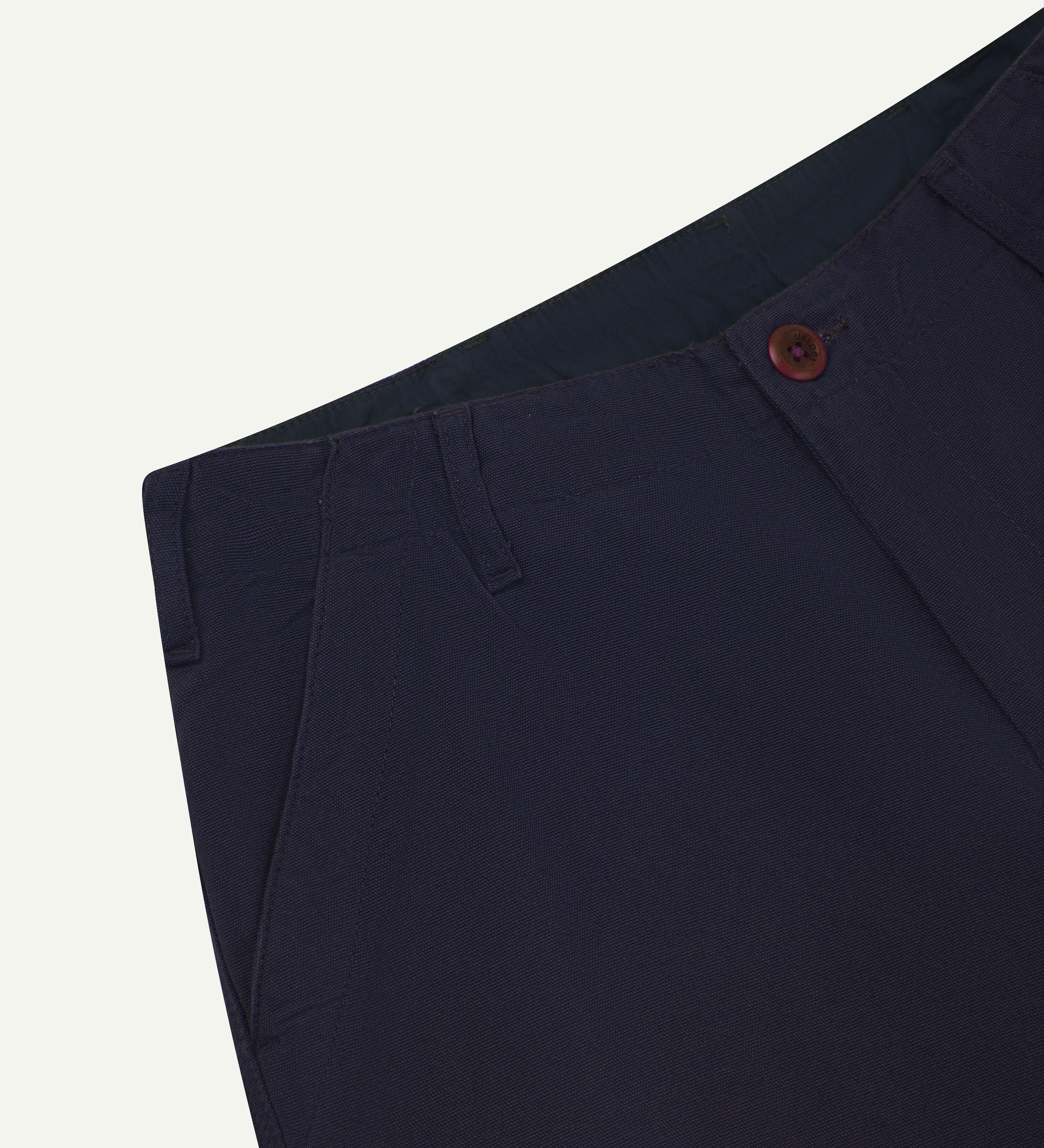 Front close-up view of uskees #5005 men's trousers in dark blue  showing front pocket, belt loops and corozo button fastening
