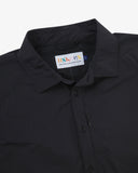 Close-up front view of black Technique trekking shirt for men showing the collar area with front ticket pocket, branding label and hanging loop.