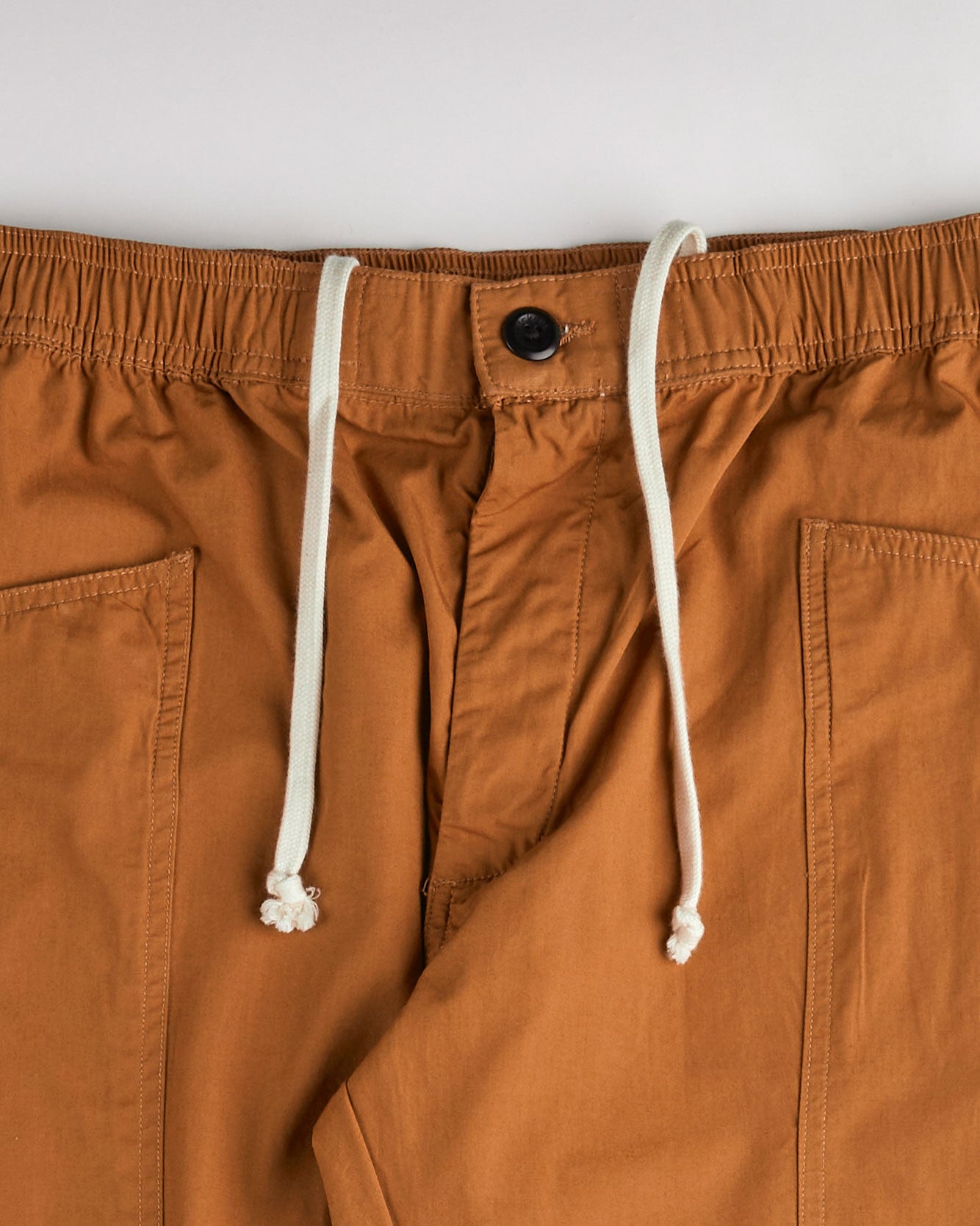 Close-up of the lightweight elasticated waist, drawstring and corozo button fastening of the Uskees #5011 lighter cotton pants.