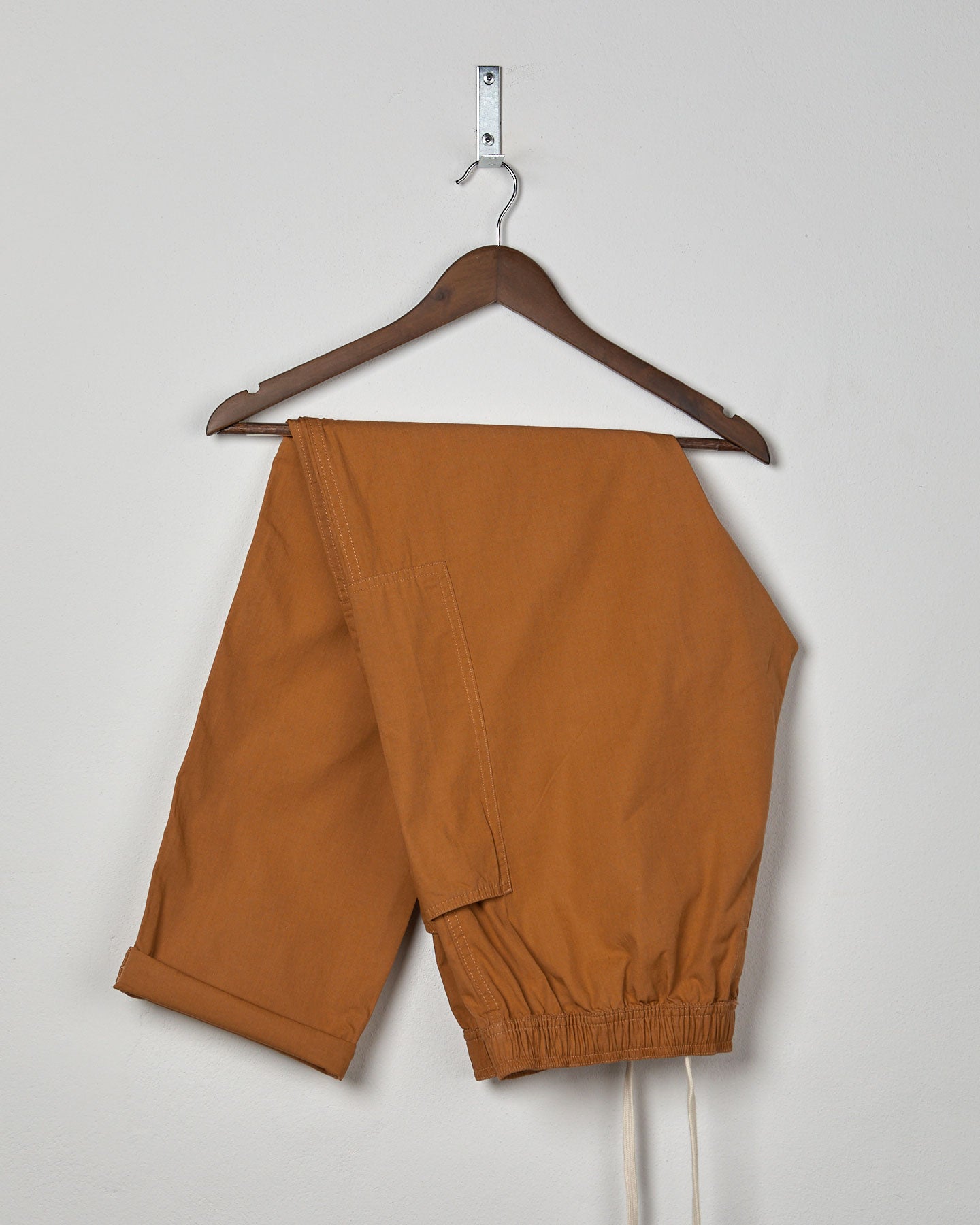 Folded front hanging shot of #5011 Uskees men's organic 'pale brown' casual trousers.