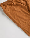 Close-up of the left pocket and stitching of the lightweight organic pale brown cotton pants.