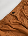 Close angled view of the lightweight elasticated waist and corozo button fastening of the pale brown #5011 Uskees pants.