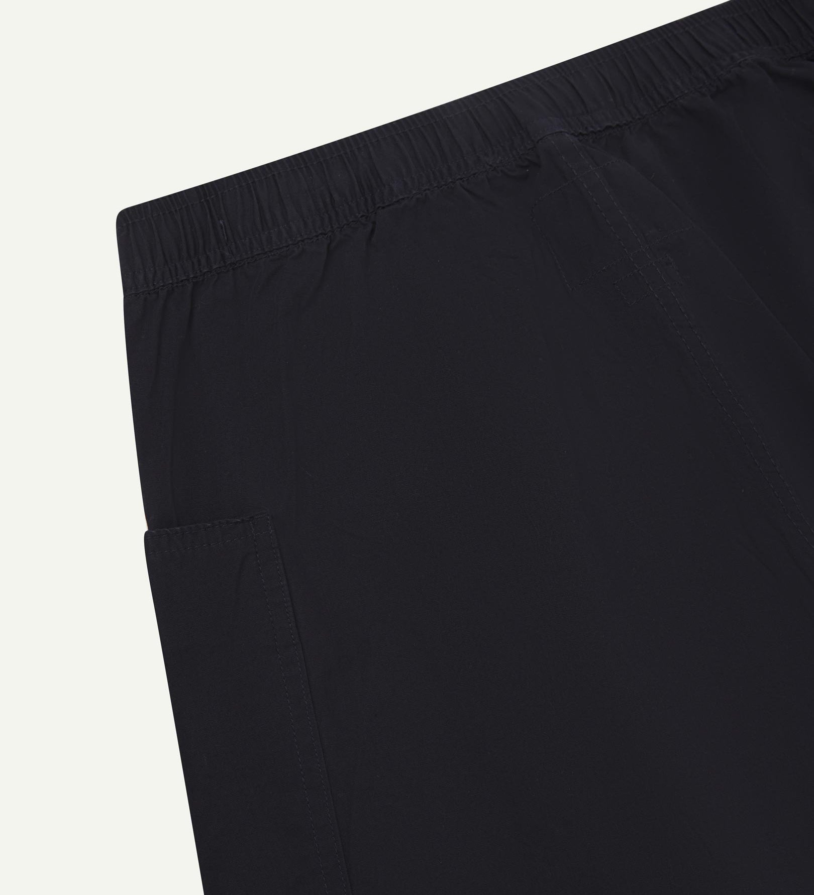 Close-up of the back of the lightweight organic midnight blue green cotton pants showing the elasticated waist.