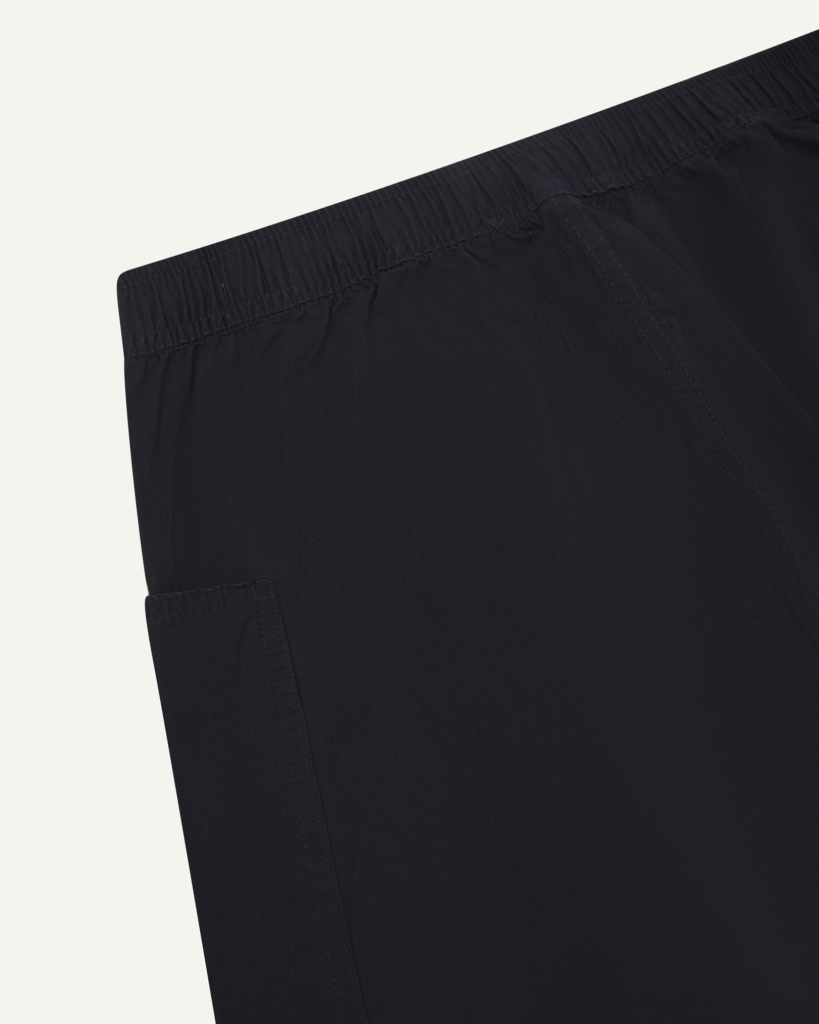 Close-up of the back of the lightweight organic midnight blue green cotton pants showing the elasticated waist.