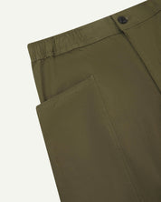 Close angled view of the elasticated waist and corozo button fastening and pockets of the olive green 5011 Uskees pants.