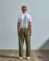 Full length back-view of model wearing olive lightweight cotton 5011 trousers showing the relaxed, tapered fit on the leg and turn-ups.