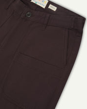 Close up shot of uskees drill dark plum men's trousers showing pocket detail and waistband