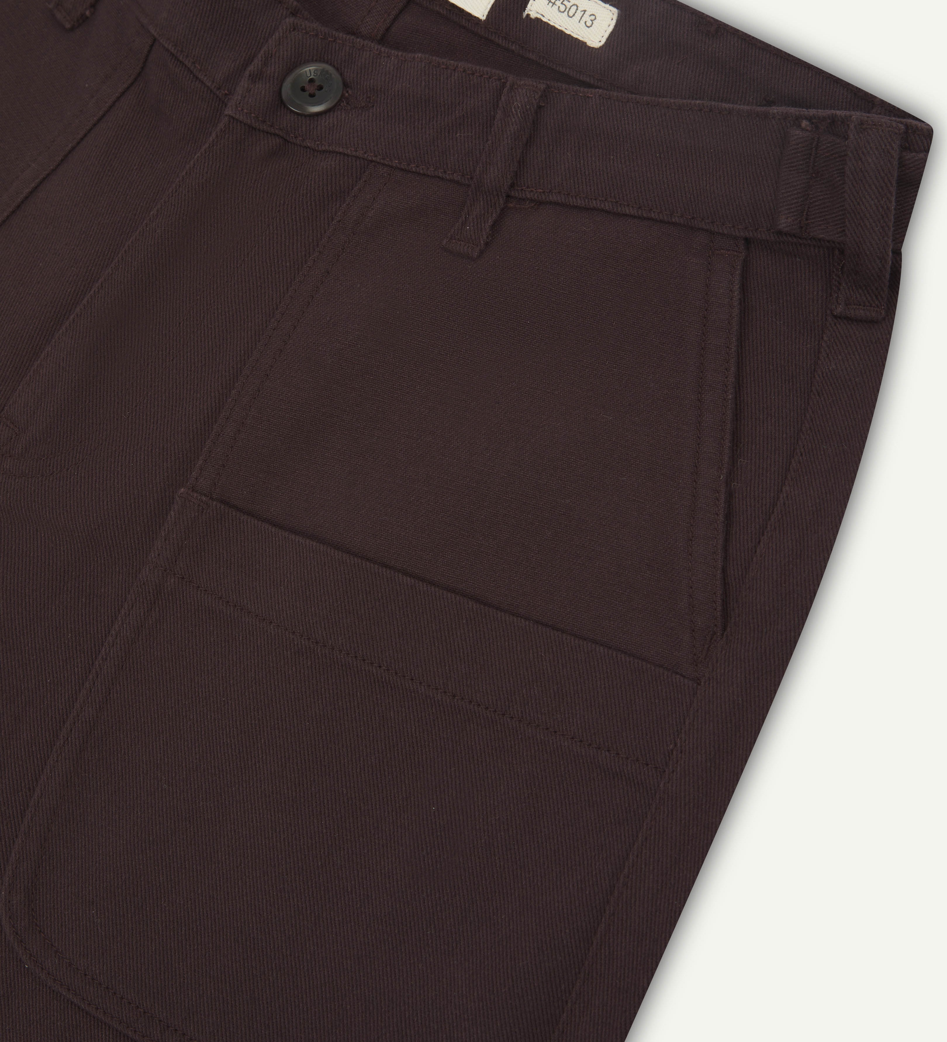 Close up shot of uskees drill dark plum men's trousers showing pocket detail and waistband