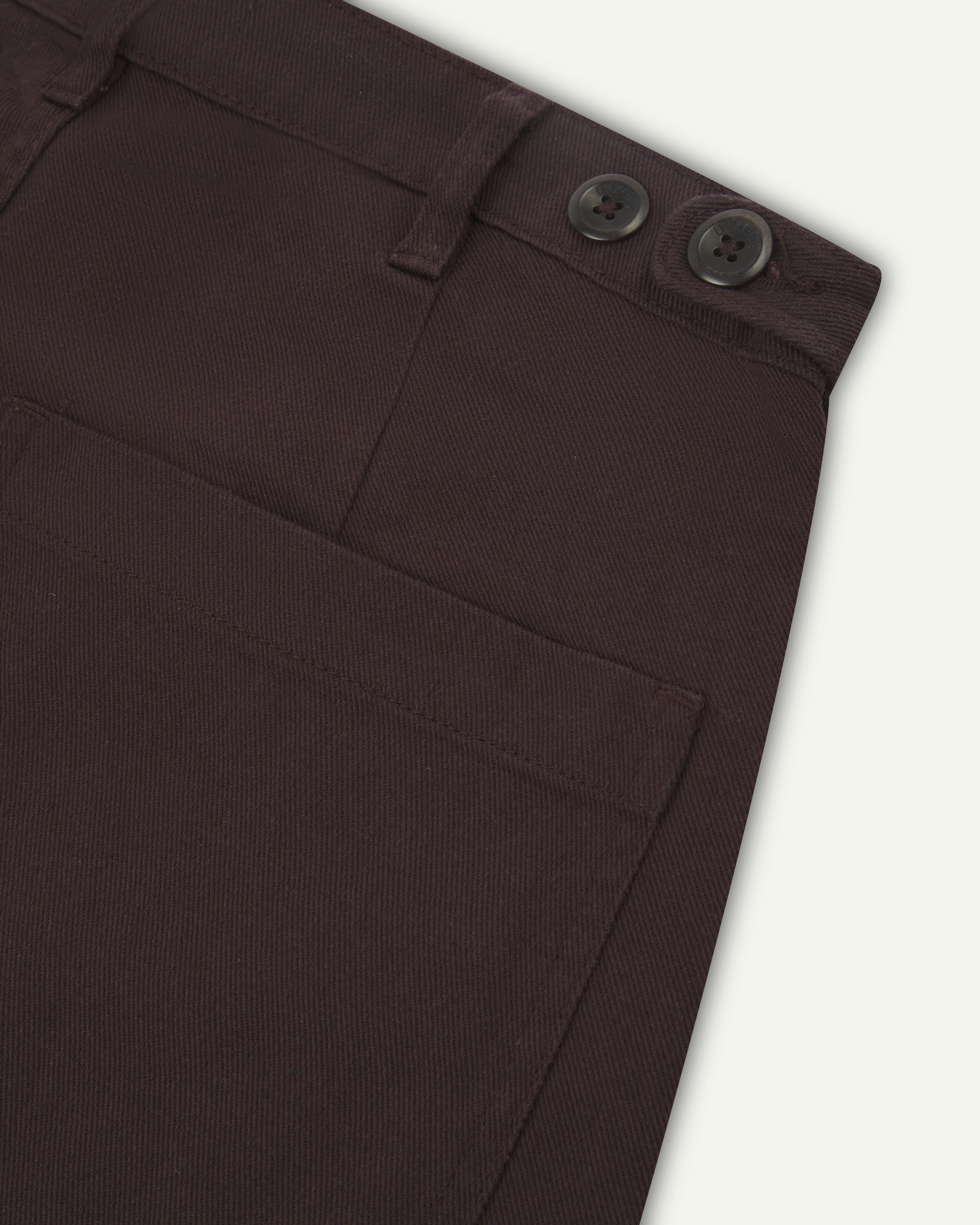 Flat shot back view of uskees dark plum drill trousers showing back pocket and waistband detail