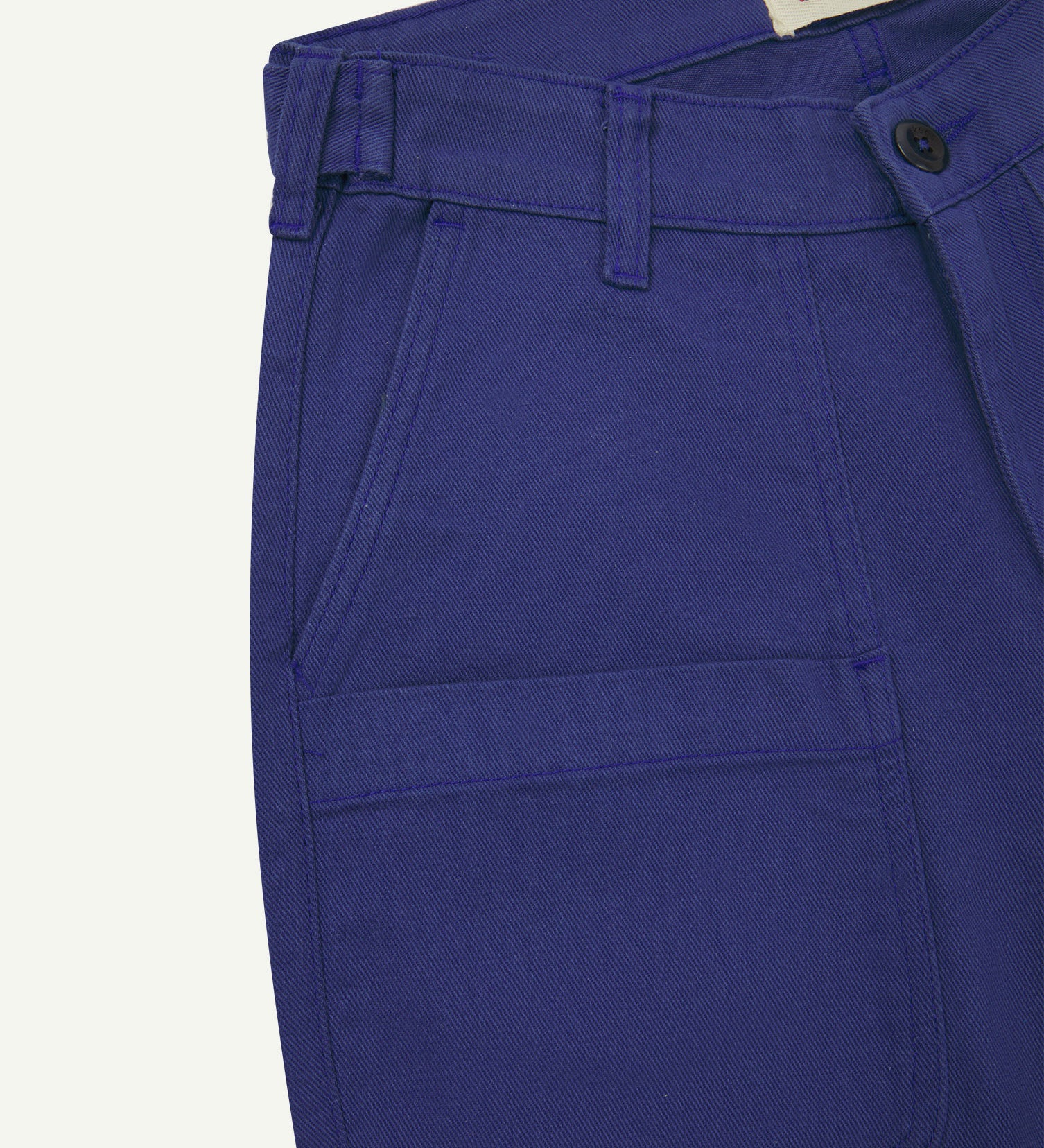 Front close-up of 5013 Uskees drill straight leg pants in ultra blue, with focus on front pockets, layered pockets, belt loops waistband and Uskees branding label.
