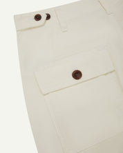 Reverse close-up of cargo pocket detailing and corozo buttons of the cream 5014 pants from Uskees.
