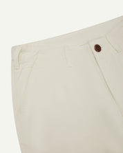 Front close-up of cream 5014 pants from Uskees with focus on contrasting waist lining fabric, side pockets and zip fly.