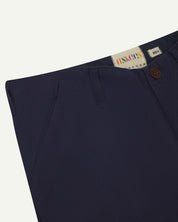Front close-up of midnight blue 5014 pants from Uskees with focus on contrasting waist lining fabric, side pockets and zip fly.