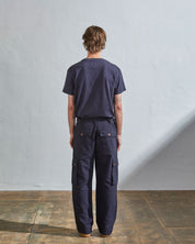 Full length back-view of model wearing midnight blue organic cotton #5014 trousers with view of rear and cargo pockets. Paired with matching t-shirt.