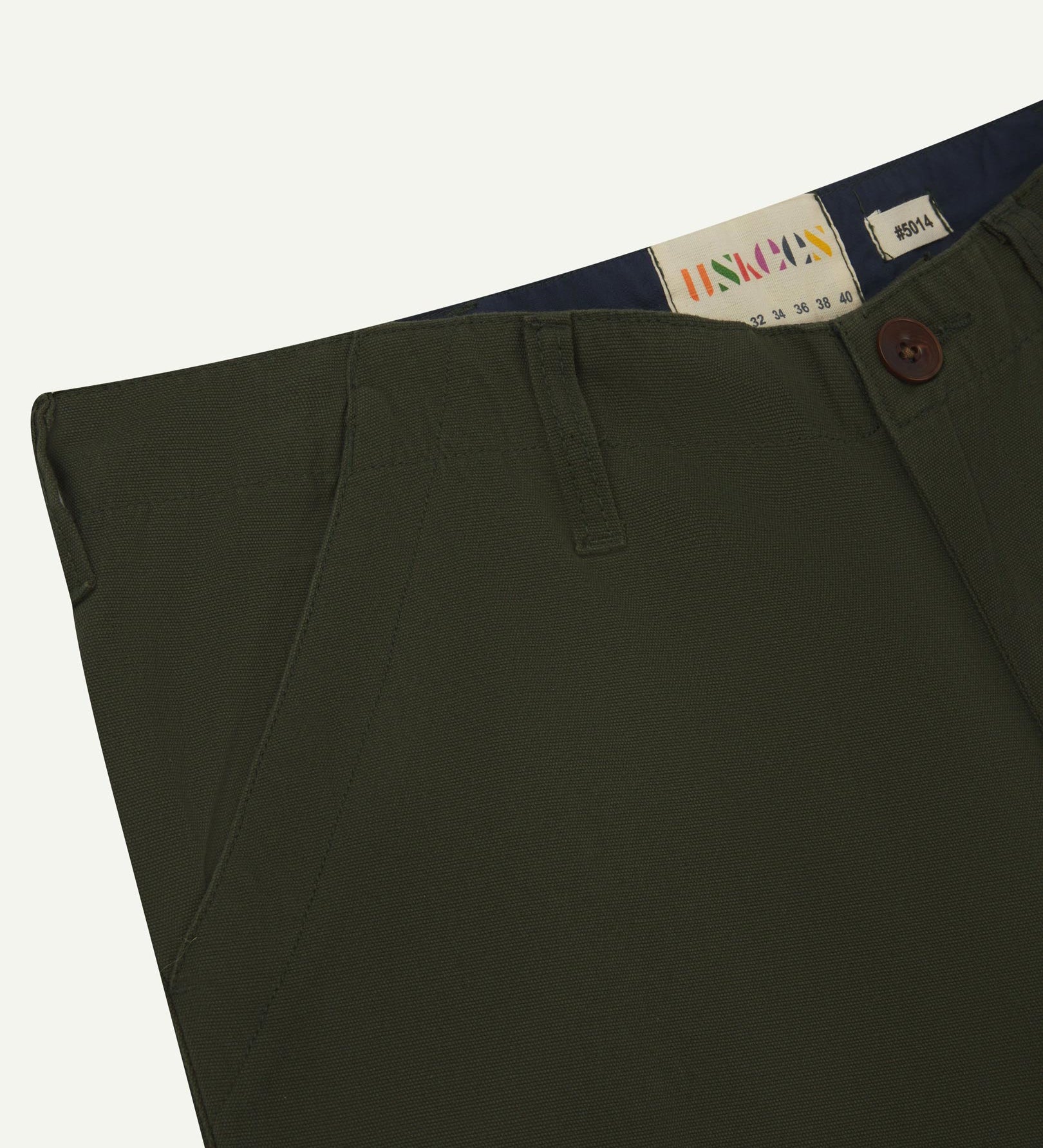 Front close-up of vine green 5014 pants from Uskees with focus on contrasting waist lining fabric, side pockets and zip fly.