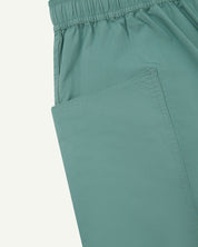 Close-up of the left pocket and stitching of the lightweight organic eucalyptus-green-green cotton shorts.