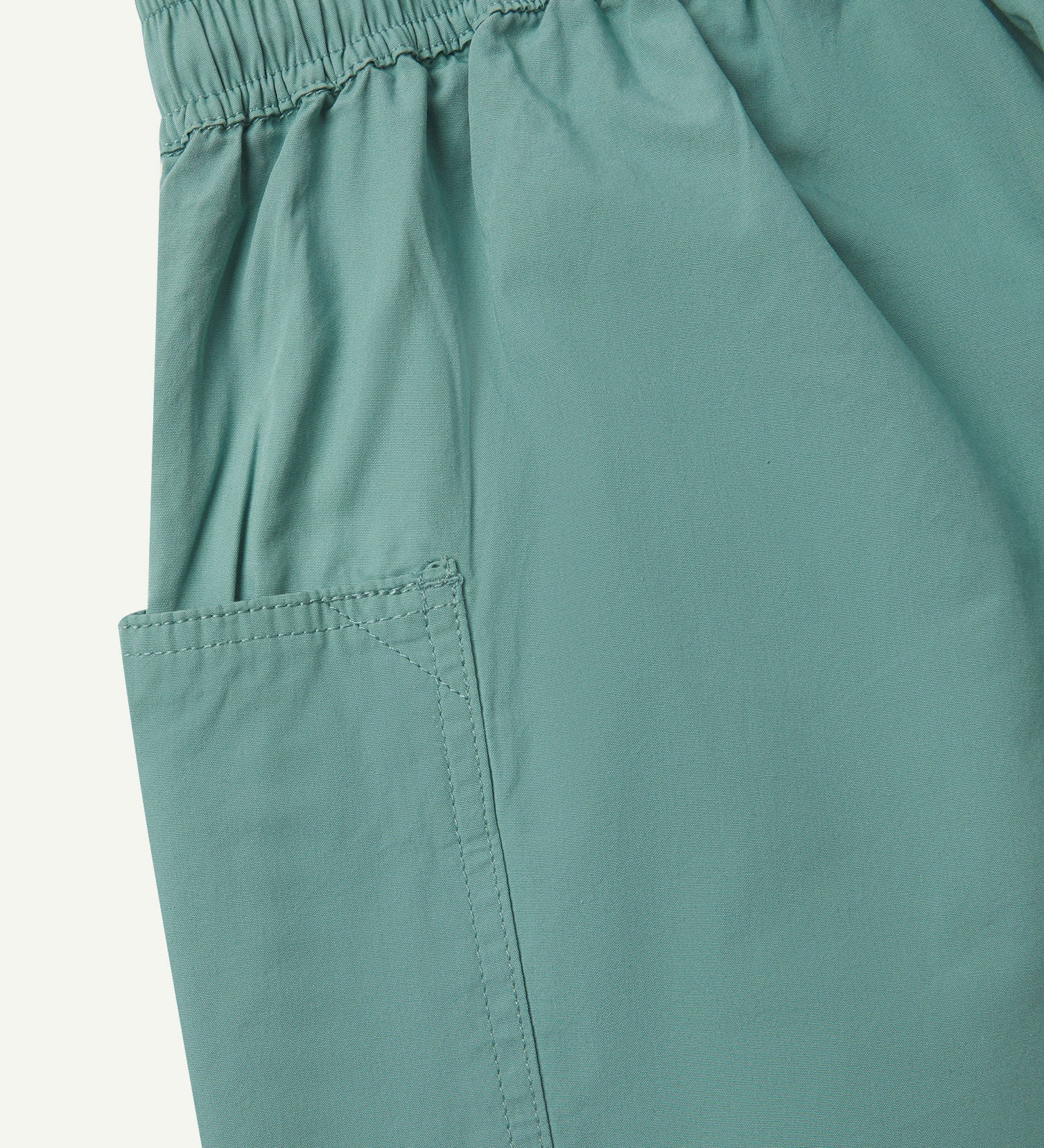 Close angled view of the lightweight elasticated waist of the eucalyptus-green-green #5015 Uskees shorts.