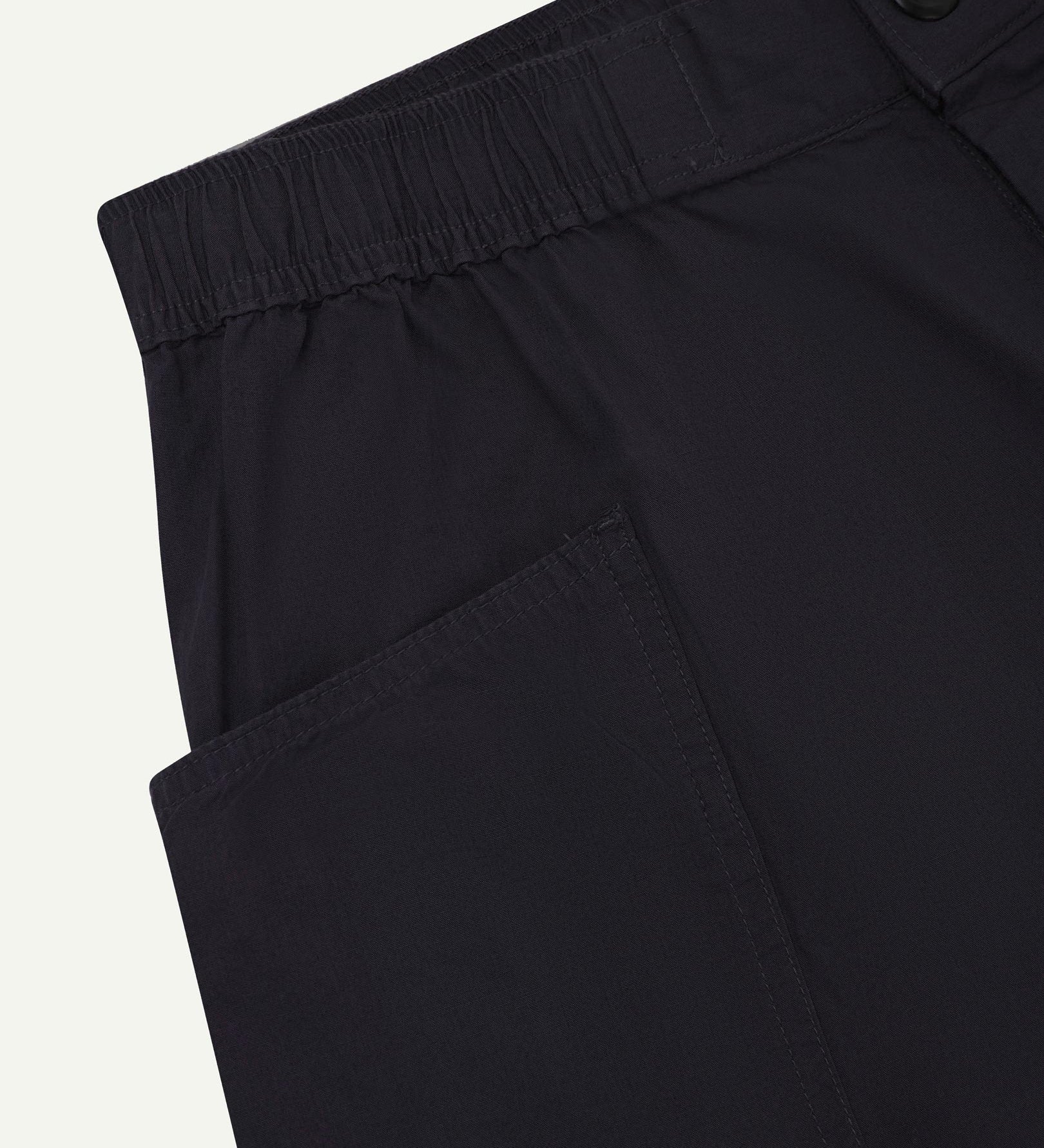 Close-up of the left pocket and stitching of the lightweight organic midnight blue-green cotton shorts.