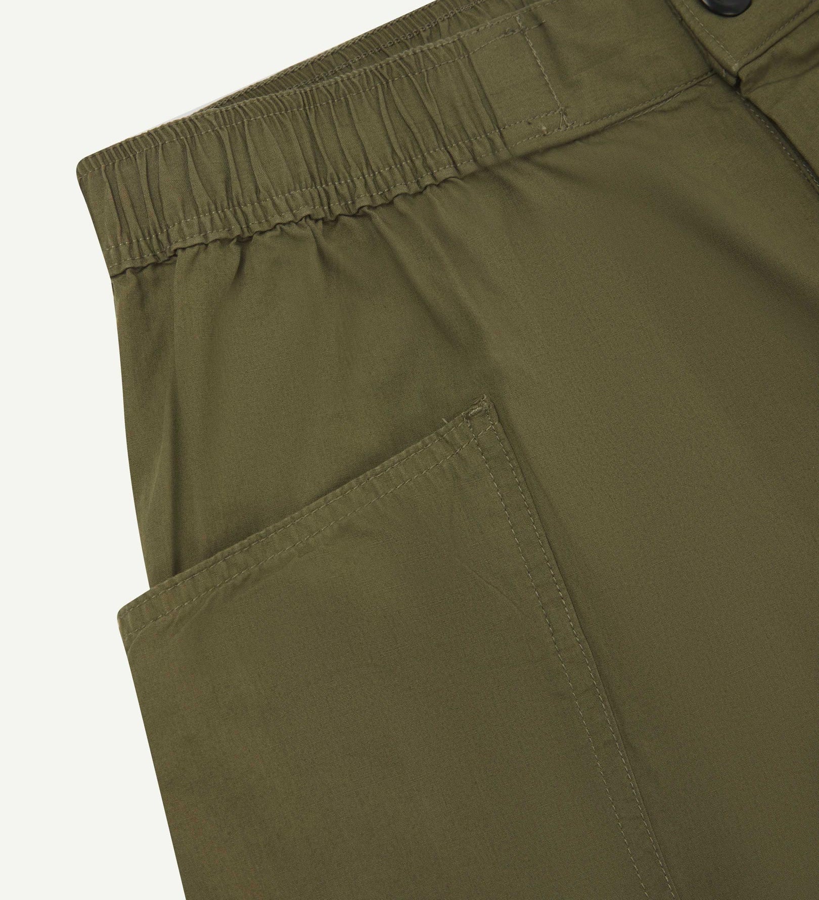 Close-up of the left pocket and stitching of the lightweight organic olive-green-green cotton shorts.