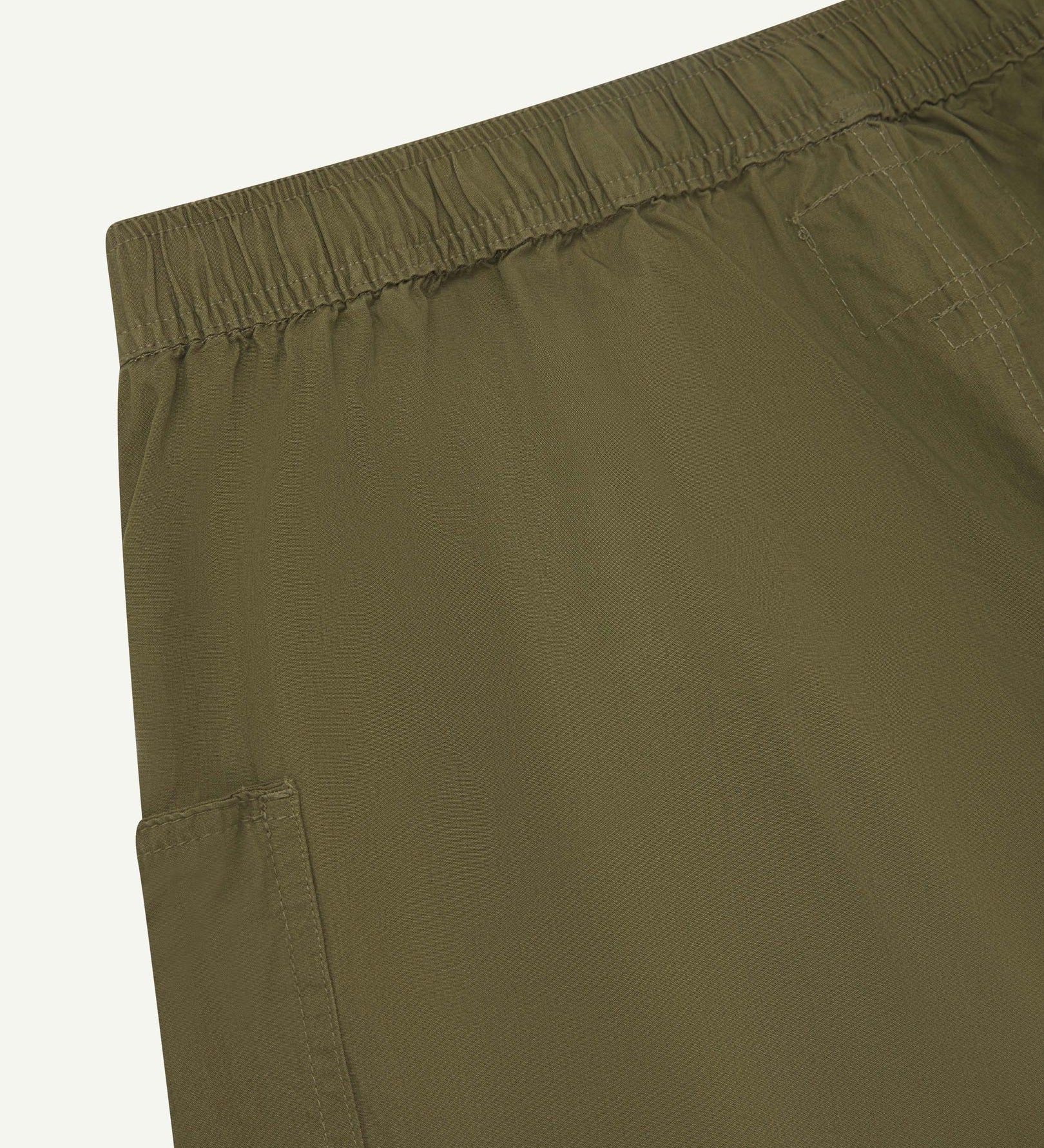 Close angled view of the lightweight elasticated waist of the olive-green-green #5015 Uskees shorts.