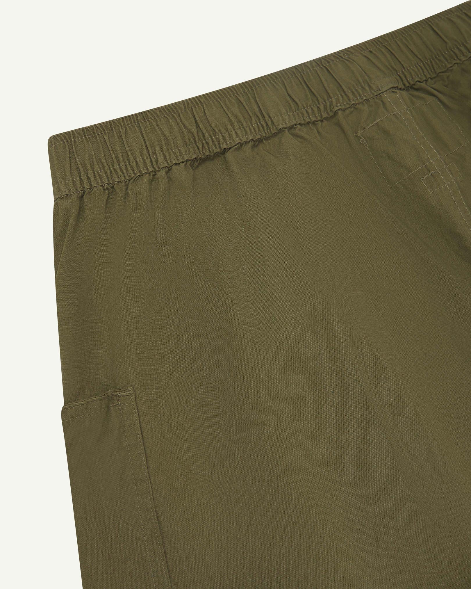 Close angled view of the lightweight elasticated waist of the olive-green-green #5015 Uskees shorts.