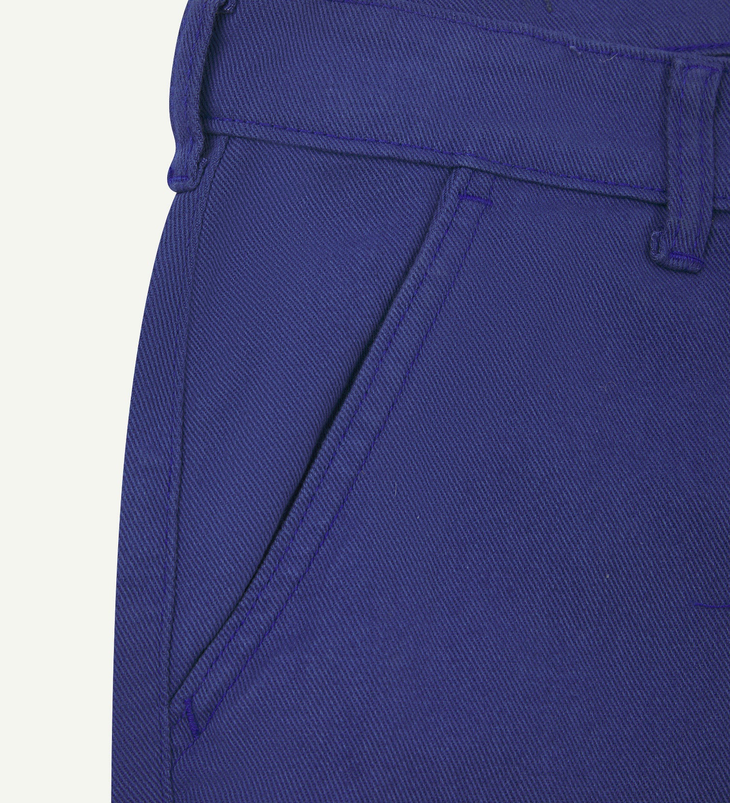 Close-up front view of the left-front pocket, belt loops and Corozo button of ultra-blue heavyweight drill pants.